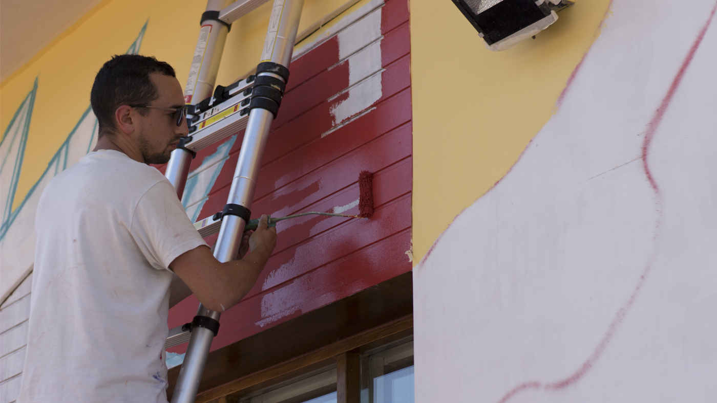 Iñigo Modrego de Ha13estudio, durante la pintura de la fachada.