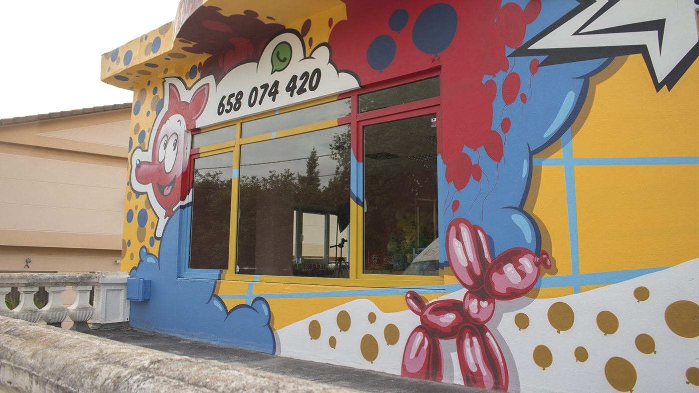 Fachada del comercio El Globo Feroz, decorada con la pintura mural realizada por Ha13estudio