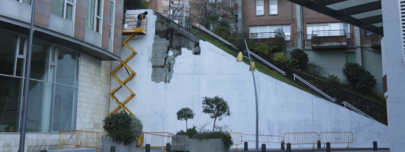 Dos personas pintando el mural de Abusu.